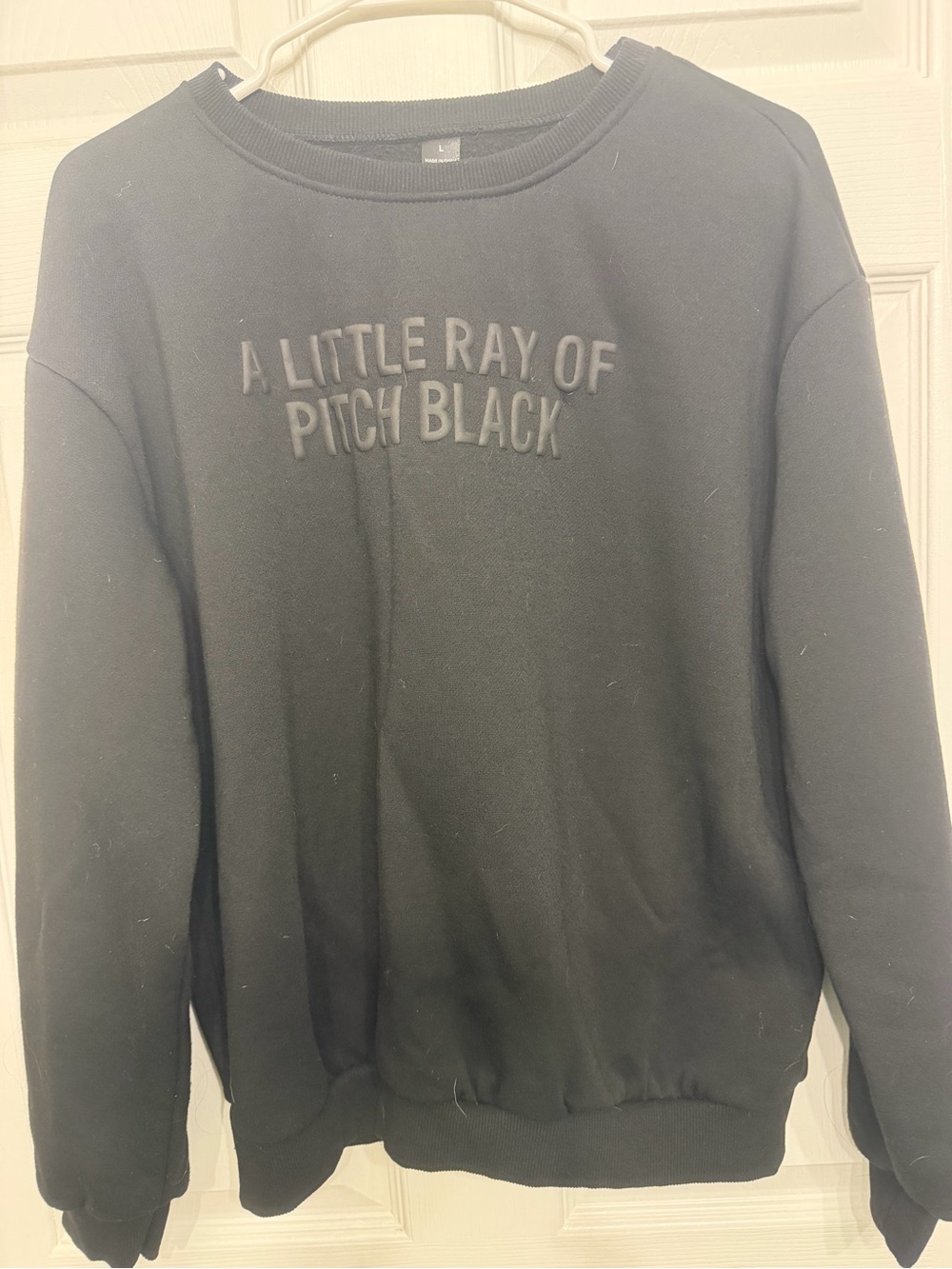 Black Crewneck Sweatshirt with Raised 'A Little Ray of Pitch Black' Text